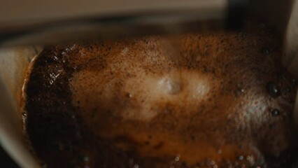 Close-up of fresh coffee brewing in coffee machine.