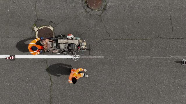 Segnaletica stradale. Verniciatura strisce pedonali e linee di mezzeria.
Vista dall'alto di operai a lavoro sulle strade.