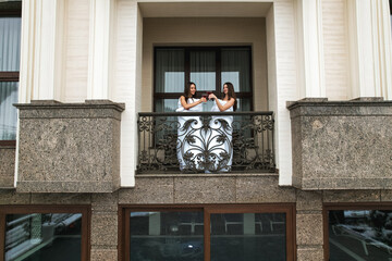 Two young women in blankets enjoying cocktails on the balcony. Hotel holiday concept