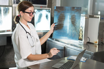 Female doctor checking anatomy and physiology x-ray film of patient in the hospital. Doctor...