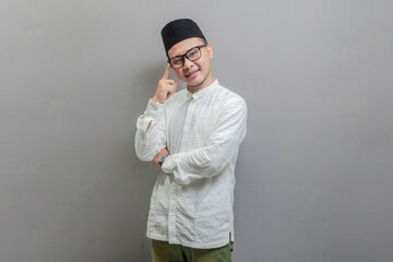 Asian Muslim man standing doing thinking gesture, looking for idea