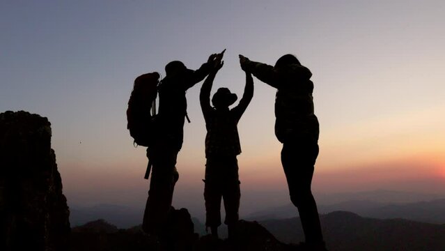 Silhouettes of a group of successful climbers on the top of a mountain.  Successfully achieving your goal. Success Business Leadership,  Successful person has achieving. teamwork.