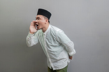 Asian Muslim man shouting and cupping hands around mouth