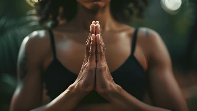 A focused shot of hands clasped together in front of the heart showcasing the surface of the skin and the subtle energy transfer that occurs during yoga poses.