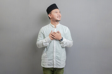 Asian Muslim man standing looking empty space happily to show grateful
