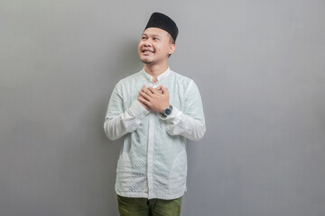 Asian Muslim man standing looking empty space happily to show grateful