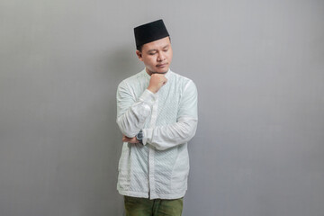 Asian muslim man thinking worried about a question, concerned and nervous with hand on chin