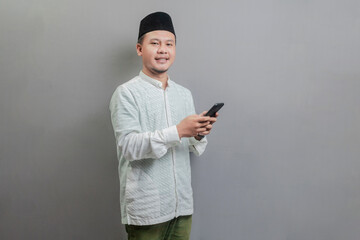 Happy asian muslim man using smart phone cellphone for calls