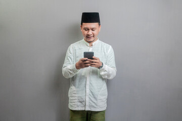 Happy asian muslim man using smart phone cellphone for calls