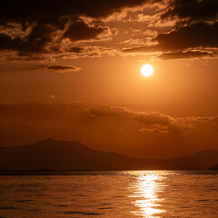 Impressive cloudy sundown orange sky over the calm sea. A magic moment in Earth paradise. Plenty of space for your text and logo.