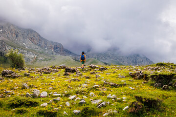 boy with a backpack on a hike against the backdrop of the mountains. child traveler with backpack,...