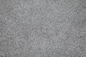 The surface of the wall is made of small white gray and black stones embedded