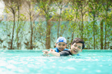 Father and son enjoy swimming together on their vacation.