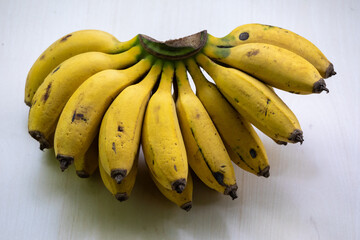 A bunch of ripe yellow bananas. Bananas are healthy fruit, they can be a good source of nutrients. It contains potassium, magnesium, vitamin B6, fiber, tryptophan, and antioxidants. - obrazy, fototapety, plakaty