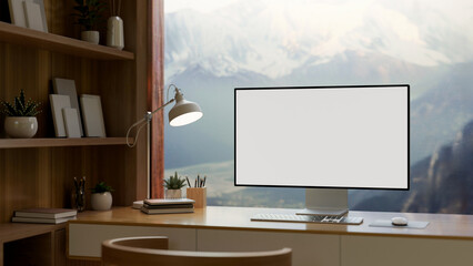 A home office features a computer mockup against the window with a view of snow-capped mountains.