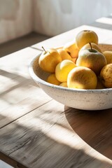 Naklejka na ściany i meble Sunlight Bathes a Plate of Fresh Apples on a Wooden Table in a Serene Indoor Setting