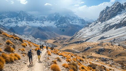 An aerial view of a winding pass through the mountains, with trekkers moving towards a distant basecamp