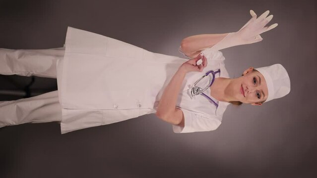 Emotional young woman doctor nurse in a white coat and hat