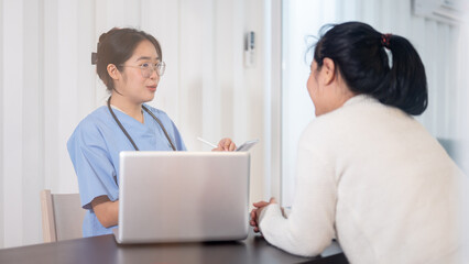 Fototapeta premium A professional Asian female doctor is consulting a female patient in the office at the hospital.