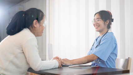 A professional Asian female doctor is consulting a female patient in the office at the hospital.