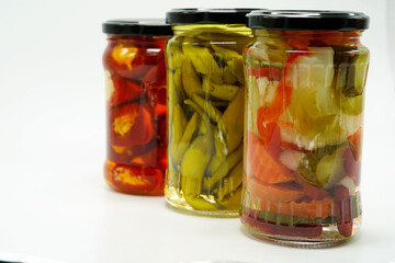 Pickles peppers tomatoes carrots chili homemade food in vase isolated at white