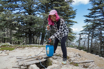 Drawing water from a cistern while trekking the Lycian Way, Turkey