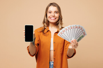 Young happy woman she wear orange shirt casual clothes hold fan of cash money in dollar banknotes...