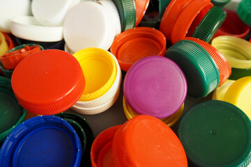 close up of red, white, blue, purple, yellow and green caps from plastic bottles. plastic...