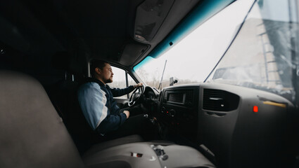 young male truck driver driving a truck, working as a driver
