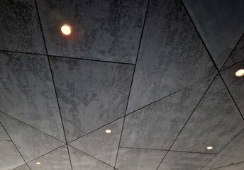 soffit ceiling with spotlights. irregular geometrical division by joints. cement look. backlit garage interior