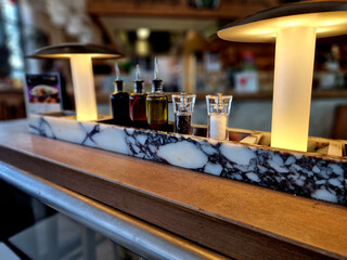 Fototapeta na wymiar marble stone counter in a luxury restaurant with condiments and salad oil. bar ready for serving. sideboard for small accessories in the pub in the evening, waiter