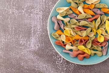 Colorful pasta background. Top view of five colors pasta shells .Heap of colorful spiral pasta,macaroni texture.