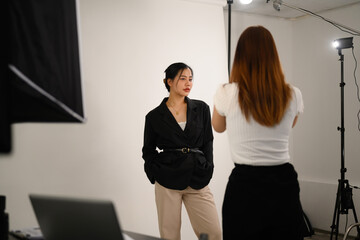 Elegant young female model posing for professional photographer in studio