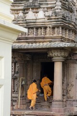 Monks walking into the entrance of a temple, ready to embark on their spiritual journey. at...
