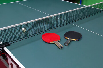 Table tennis ball and two rackets on the table - stock photo