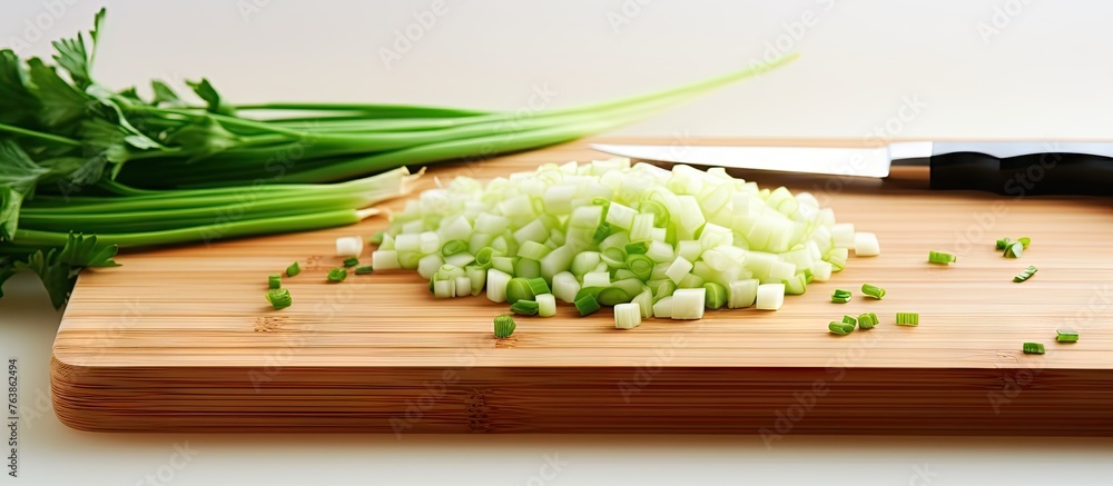 Wall mural Chopped green onions on a cutting board with a knife