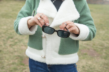 Young girl holding sunglasses at outdoor.