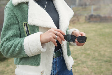 Young girl holding sunglasses at outdoor.