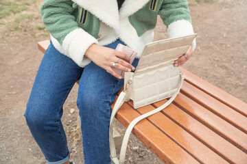 Young girl showing handbag in outdoor.