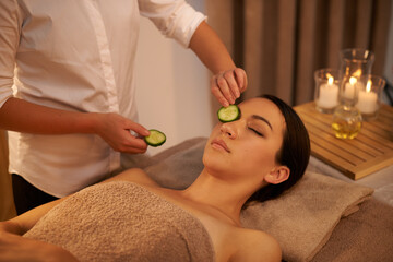 Face, massage therapist and woman with cucumber in spa for peace, relax or wellness. Facial, salon or hands apply vegetable on eyes for natural beauty, skincare or healthy organic treatment with mask