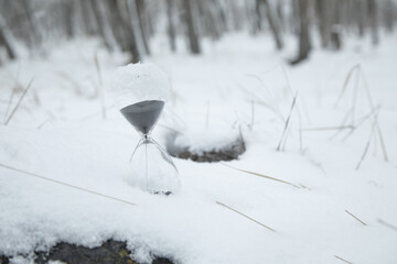 Hourglass on snow at winter.