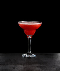 Strawberry margarita on black concrete background. Berries alcohol drink with tequila and strawberry in minimal style. Dark concept drink menu. Berry margarita in classic glass on dark background.