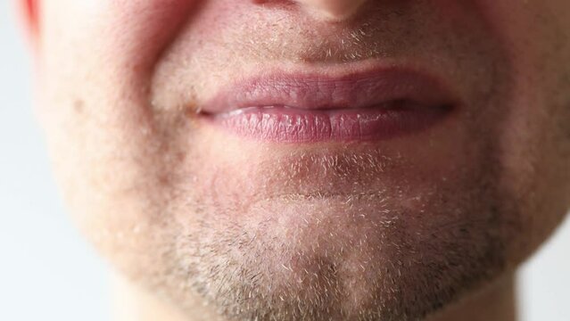 Man's mouth grimaces at camera. Slight unshaven face