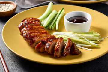 Traditional Peking duck served with cucumber slices, scallions, and hoisin sauce, styled for an elegant feast