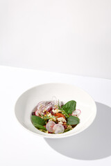 Greek salad isolated on a white background with crisp vegetables and feta cheese
