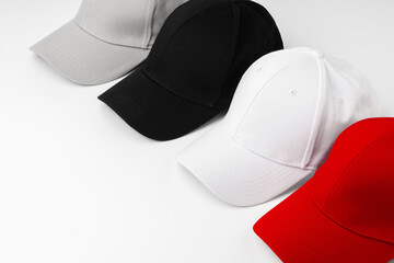 Lineup of Four Blank Baseball Caps in Red, White, and Black on a White Background - 763876818