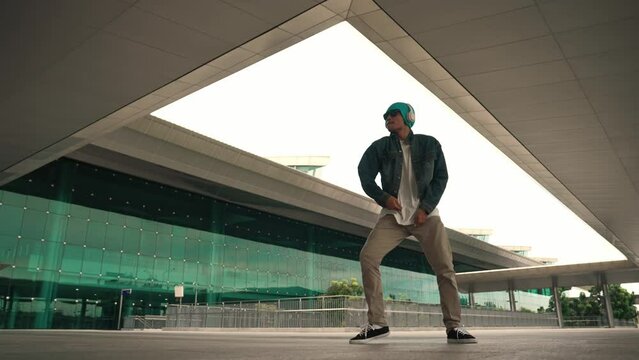 Panorama shot of happy hipster dance together while listen music from headphone at mall. Professional break dancer enjoy perform b boy footstep. Outdoor sport 2024. Modern street dancing. Sprightly.