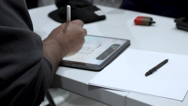 Man Draws On Tablet Computer With A Stylus Pen At His Office Desk. Close-up shot