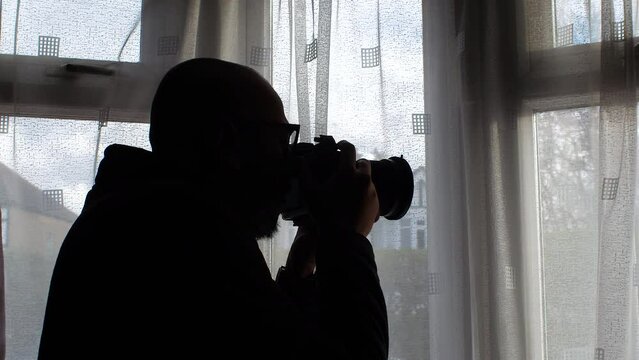 Man Taking Picture With Camera Out Of Window At Home - Close Up