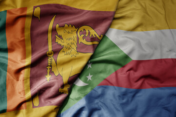 big waving national colorful flag of comoros and national flag of sri lanka .